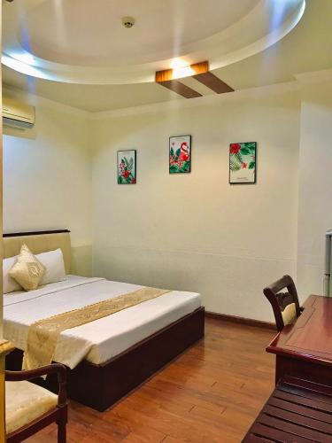 a bedroom with a bed in a room with a table at Linh Phuong 8 Hotel - 24 hours stay in Can Tho