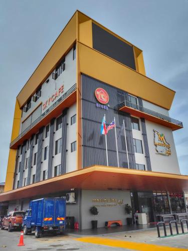 a large building with a truck parked in front of it at Hotel Marudu Inn in Pingan Pingan