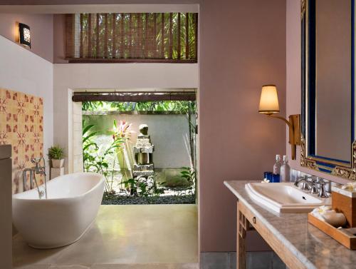 a bathroom with a large tub and two sinks at Sudamala Resort, Sanur, Bali in Sanur