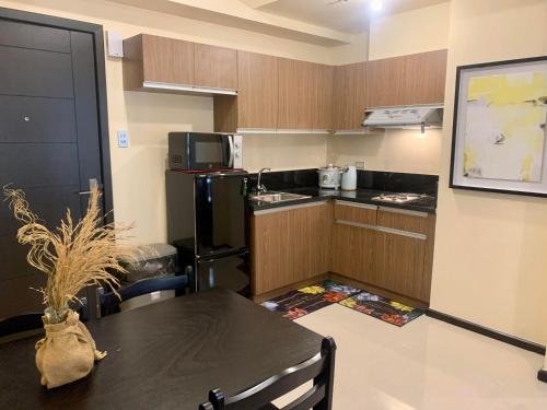 eine Küche mit einem Tisch und einem schwarzen Kühlschrank in der Unterkunft The Radiance Manila Bay in Manila
