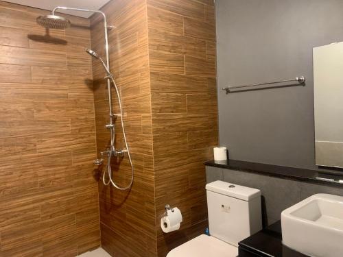 a bathroom with a shower with a toilet and a sink at The Radiance Manila Bay in Manila