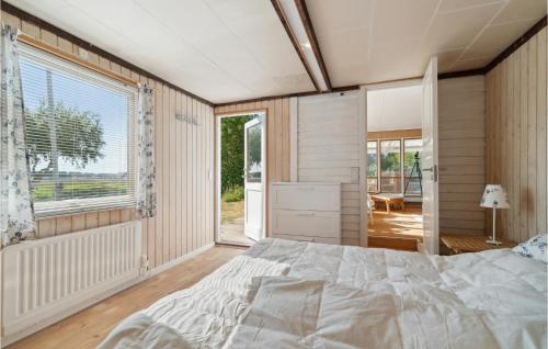 a bedroom with a bed and a large window at Nice Home In Or With House Sea View in Orø