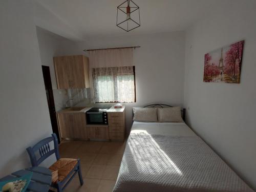a small bedroom with a bed and a kitchen at Andre House in Mesimvría