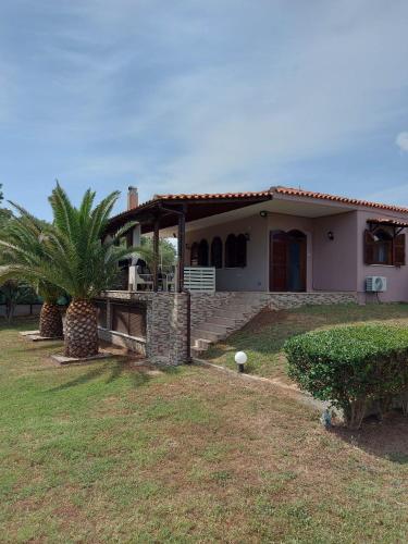 a house with a palm tree in front of it at Andre House in Mesimvría