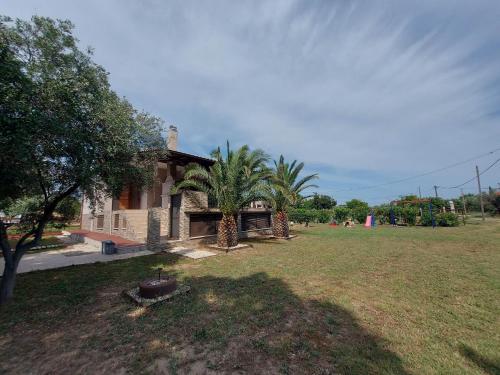 una casa con una palmera en un patio en Andre House en Mesimvría