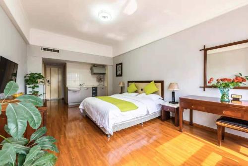 a bedroom with a bed and a desk and a piano at Ha Luo Hotel in Kunming