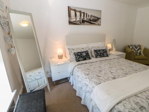 una camera con un grande letto e uno specchio di Hollie Cottage a Haltwhistle