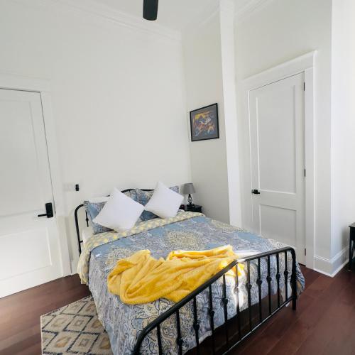 a bedroom with a bed with a yellow blanket on it at Walk to French Quarter House of Jazz & Blue Suite in New Orleans