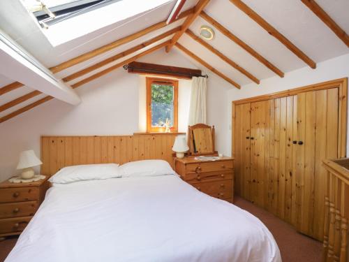 een slaapkamer met een wit bed en een raam bij Wren's Nest in Keswick