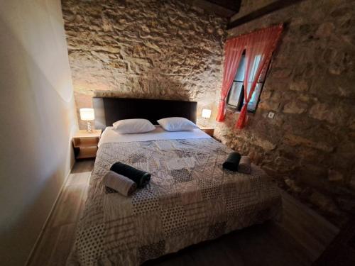 um quarto com uma cama e uma parede de pedra em Apartman Zrinka em Jesenice