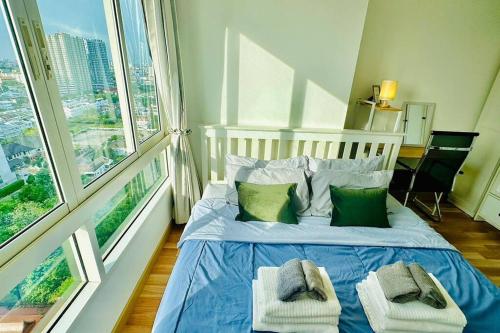1 dormitorio con 1 cama con sábanas azules y almohadas verdes en High-Class 2BED Condo Just 1-Step from BTS ONNUT en Bangkok