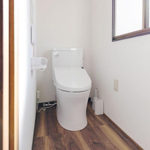 a white toilet in a bathroom with a wooden floor at 松本はなれ Matsumoto HANARE - Japanese style private bedroom Guest hause in Matsumoto