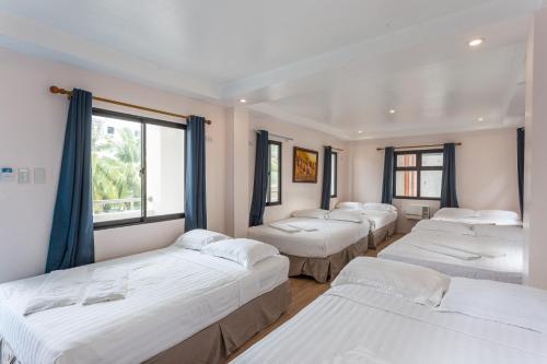 a row of beds in a room with windows at Island Inn in Boracay