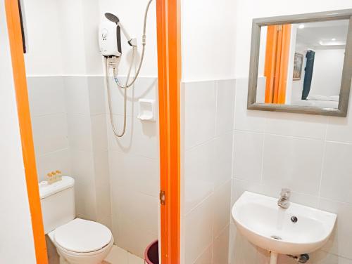 a bathroom with a shower and a toilet and a sink at Island Inn in Boracay