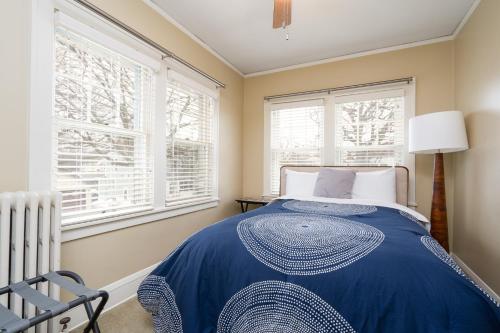 ein Schlafzimmer mit einem Bett und zwei Fenstern in der Unterkunft Twin City Terrace in Minneapolis