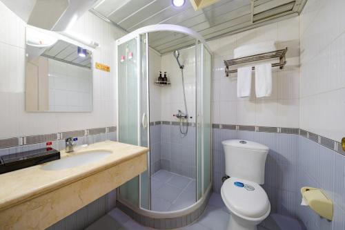 a bathroom with a shower and a toilet and a sink at Ha Luo Hotel in Kunming