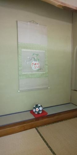 a wall with a picture of a bowl on a shelf at Yamanouchi sekisan chi in Yokokura