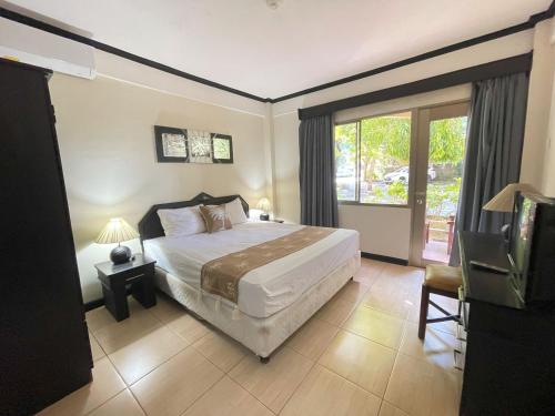 a bedroom with a large bed and a window at Beach Apartment inside Resort Walking Distance to the beach in Seminyak