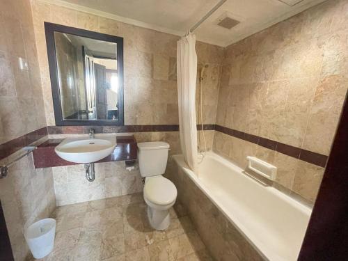 a bathroom with a toilet and a sink and a tub at Beach Apartment inside Resort Walking Distance to the beach in Seminyak