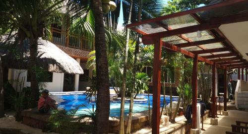 a person sitting next to a swimming pool in a resort at birdwatchers beachfront hotel panglao in Panglao