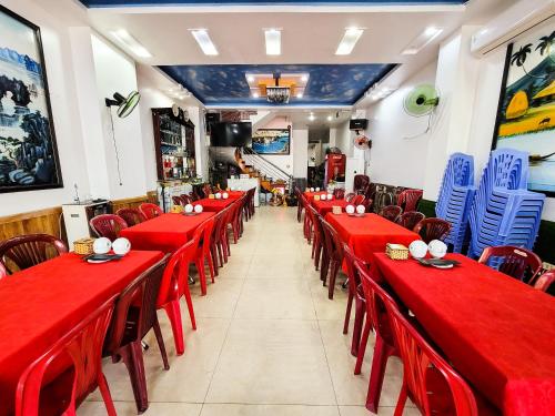 a dining room with red tables and chairs at Nhật Anh Hotel Cát Bà in Cat Ba