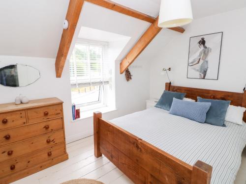 ein Schlafzimmer mit einem Holzbett und einem Fenster in der Unterkunft 3 Bridge Villas in Narberth