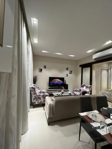 Hawana salalah Apartment Mimosa في صلالة: غرفة معيشة مع أريكة وتلفزيون