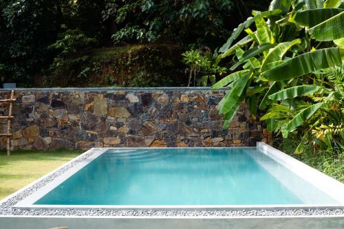 a swimming pool in front of a stone wall at The Well in Ahangama