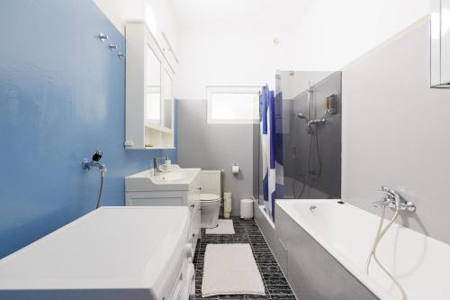 ein Badezimmer mit zwei Waschbecken, einer Badewanne und einer Dusche in der Unterkunft NEW ShalalaLiving Vienna Spacious Home for Family & Friends in Wien
