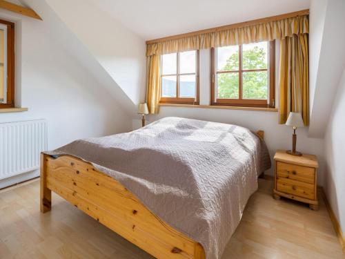 ein Schlafzimmer mit einem Bett und zwei Fenstern in der Unterkunft Holiday apartment in Mariapfarr near ski area in Mariapfarr