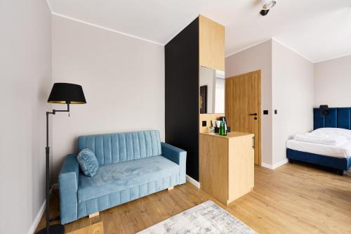 a bedroom with a blue chair and a bed at Apartamenty Na Skarpie in Płock