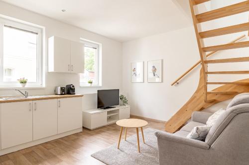 eine Küche und ein Wohnzimmer mit weißen Schränken und einer Treppe in der Unterkunft Villa Matylda in Marienbad