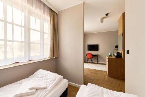 a bedroom with a bed and a window and a desk at Apartamenty Na Skarpie in Płock