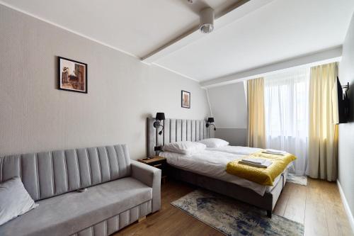 a bedroom with a bed and a couch at Apartamenty Na Skarpie in Płock