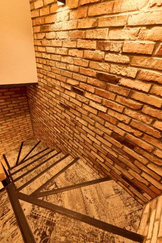 a brick wall and a wooden table in a room at Apartamenty Na Skarpie in Płock