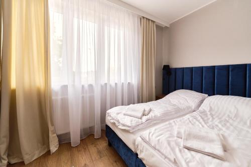 a bedroom with a bed and a large window at Apartamenty Na Skarpie in Płock