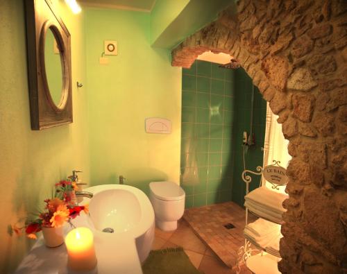 a bathroom with a white toilet and a sink at Blu Bosa in Bosa