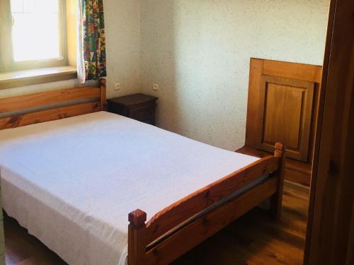 a bedroom with a wooden bed in a room with a window at Stylish house in the countryside 5 km from the sea in Darłowo
