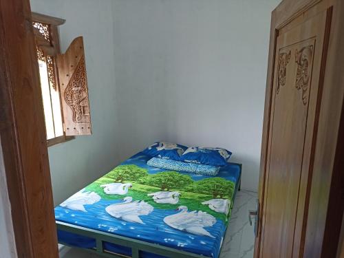 - un lit avec une couette bleue et des cygnes dans l'établissement Hexa Jongkangan, à Bugisan