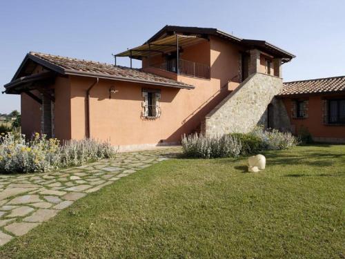 a house with a grass yard next to a building at Holiday apartment on a farm in Umbria in Bettona