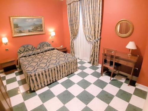 a bedroom with a bed and a checkered floor at Hotel Mariano in Rome