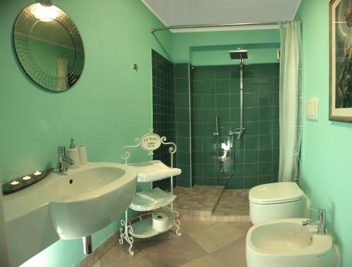 a bathroom with a sink and a toilet and a shower at Blu Bosa in Bosa