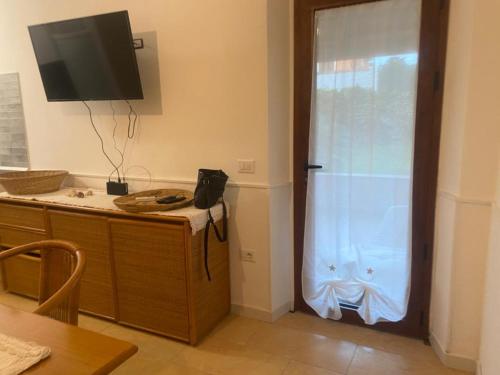 eine Küche mit einer Glasschiebetür und einem TV in der Unterkunft Il Nespolo Casa Vacanze a due passi dal mare in Olbia