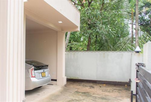 a car parked in a garage next to a fence at Transit Trails in Katunayake