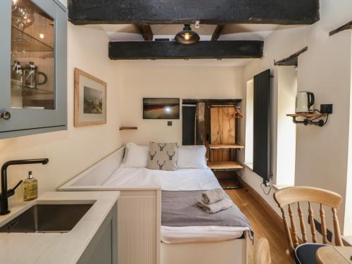 Habitación pequeña con cama y lavamanos en Woodbine Retreat, en Buxton