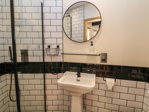 a bathroom with a sink and a mirror at Woodbine Retreat in Buxton