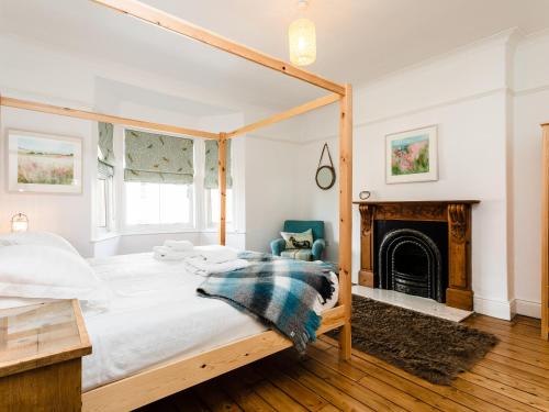 a bedroom with a bed and a fireplace at Longshore in Alnmouth