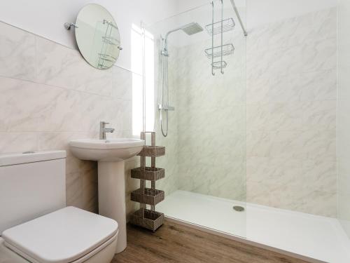 a bathroom with a sink and a toilet and a shower at Longshore in Alnmouth