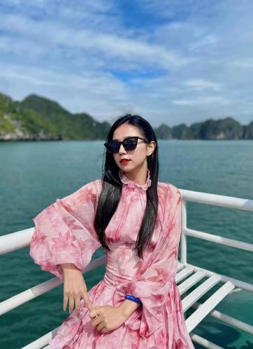 a woman in a pink dress sitting on a boat at Nhật Anh Hotel Cát Bà in Cat Ba