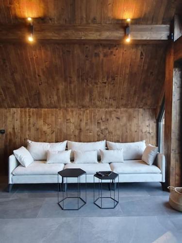 a living room with a white couch and two tables at Vrleti Tare in Bajina Bašta